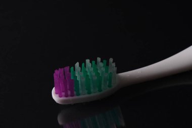 Su damlalarıyla siyah zemin üzerinde diş fırçası 