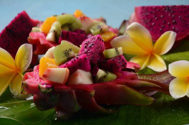 Ejderha meyvesi (Pitaya, Pitahaya) Karışık Pitahaya meyvesi ve meyve salatası, ve frangipani çiçekleri.