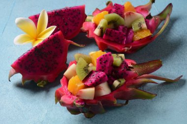 Ejderha meyvesi (Pitaya, Pitahaya) Karışık Pitahaya meyvesi ve meyve salatası, ve frangipani çiçekleri.