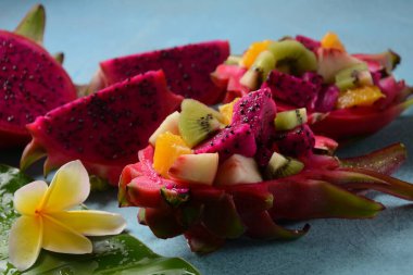 Ejderha meyvesi (Pitaya, Pitahaya) Karışık Pitahaya meyvesi ve meyve salatası, ve frangipani çiçekleri.