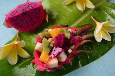Ejderha meyvesi (Pitaya, Pitahaya) Karışık Pitahaya meyvesi ve meyve salatası, ve frangipani çiçekleri.