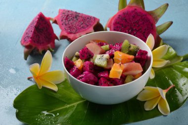 Ejderha meyvesi (Pitaya, Pitahaya) Karışık Pitahaya meyvesi ve meyve salatası, ve frangipani çiçekleri.