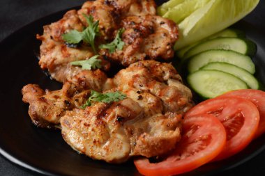 Domatesli ızgara tavuk bifteği, zeytinyağı, biber, salatalık ve bitkiler..