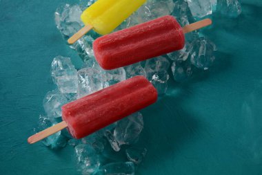 Mavi arka planda buzlu çilekli dondurma ve limonlu dondurma. 