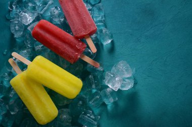 Mavi arka planda buzlu çilekli dondurma ve limonlu dondurma. 