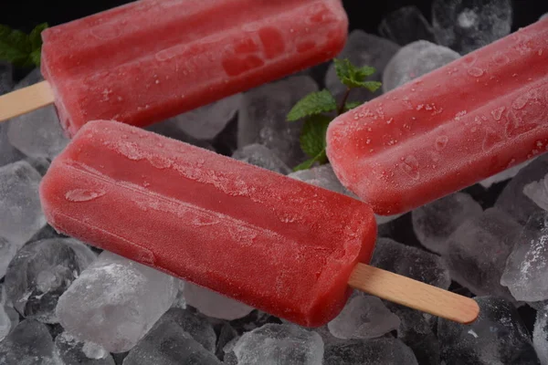 Strawberry popsicle on ice background