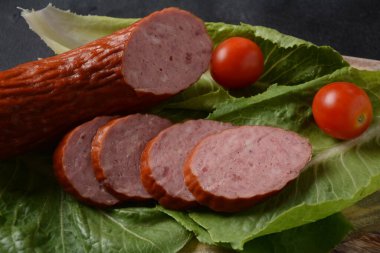 Dilimlenmiş baharatlı biftek / domuz sosisi. Marul yaprağı ve kiraz domatesli..