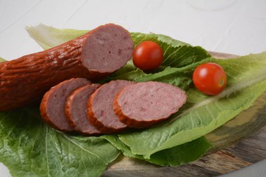 Dilimlenmiş baharatlı biftek / domuz sosisi. Marul yaprağı ve kiraz domatesli..