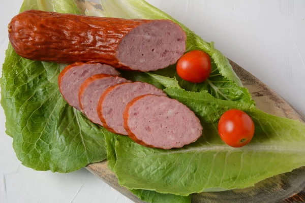 Sliced spicy smoked beef/ pork sausage.With lettuce leaf and cherry tomatoes.