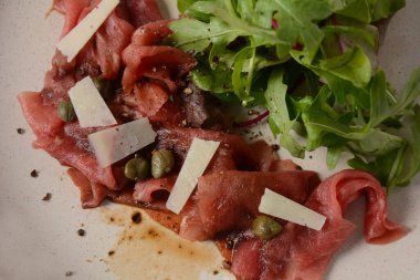 Parmesanlı sığır eti, kapari ve roka. Zeytinyağı ve soya soslu.