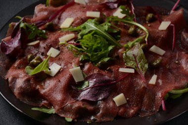 Parmesanlı sığır eti, kapari ve roka. Zeytinyağı ve soya soslu.