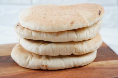 Tahta üzerinde bir yığın Pita ekmeği (düz ekmek)