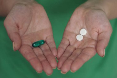 Renkli hapları onun elinde tutan kadın