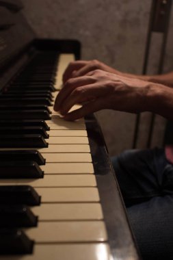 Bir müzisyen piyano çalıyor. Müzisyen veya besteci piyano tuşları uzun parmaklarıyla dokunur. Konsept: ses, müzik, Akademi, konser, pian