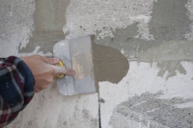 adam duvar kaymağını bir spatula ile