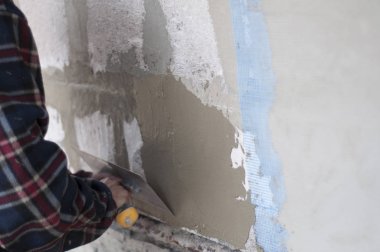 adam duvar kaymağını bir spatula ile