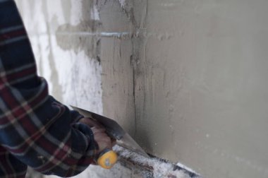 adam duvar kaymağını bir spatula ile