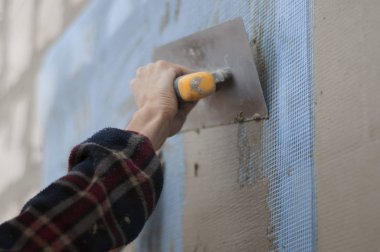 adam duvar kaymağını bir spatula ile