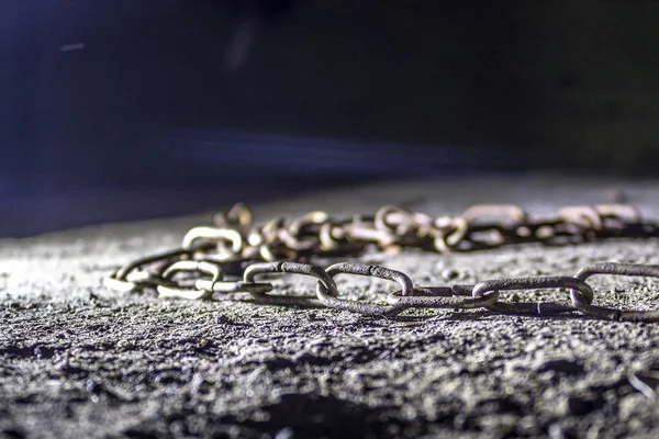 Vieja cadena oxidada tendida en el suelo . — Foto de Stock