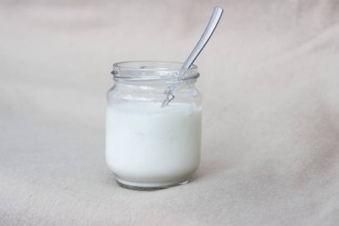 white yogurt in glass jar on table for breakfast clipart