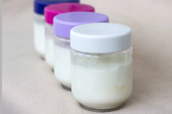 Porcja świeżego naturalnego domowego jogurtu organicznego w szklanej misce z kolorowymi osłonami — Zdjęcie stockowe