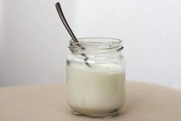 Yogurt bianco in barattolo di vetro sul tavolo per colazione — Foto Stock