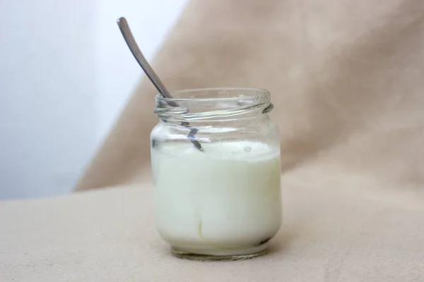 White yogurt in glass jar on table for breakfast — Stock Photo, Image