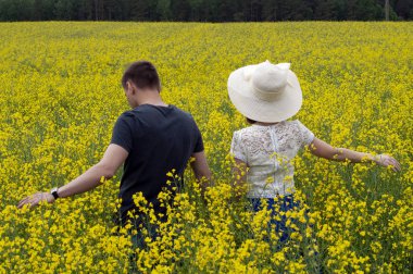 Sarı bir kolza alanında güzel çift