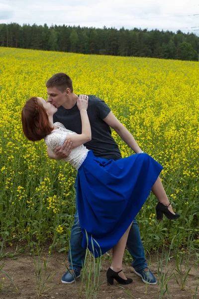 Belo casal em um campo de colza amarelo — Fotografia de Stock