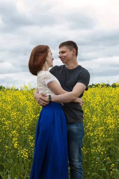 Belo casal em um campo de colza amarelo — Fotografia de Stock