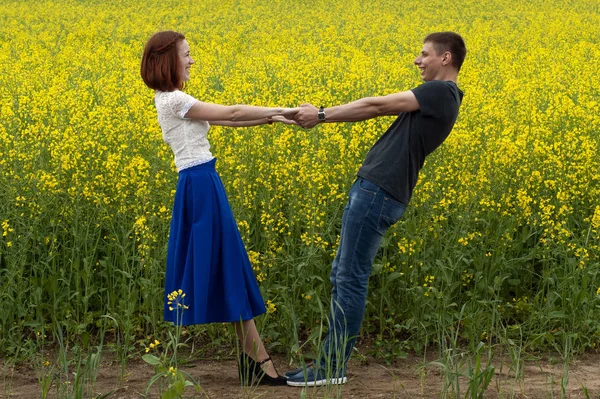 Belo casal em um campo de colza amarelo — Fotografia de Stock