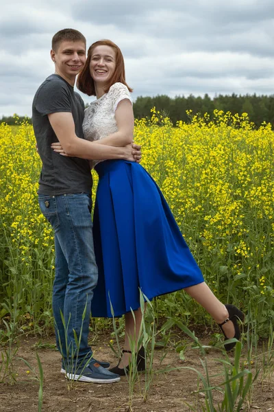 Belo casal em um campo de colza amarelo — Fotografia de Stock