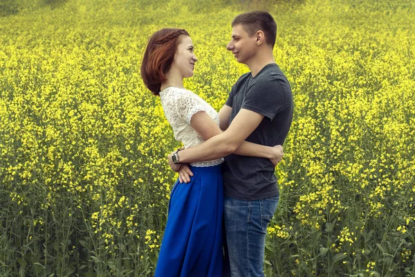Vackert par i ett gult rapsfält — Stockfoto