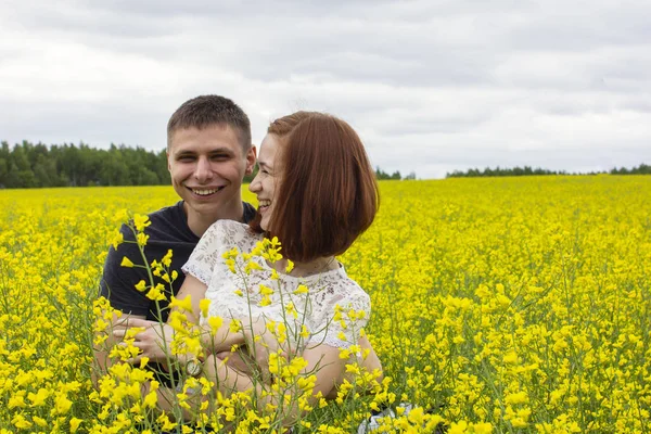 Belo casal em um campo de colza amarelo — Fotografia de Stock