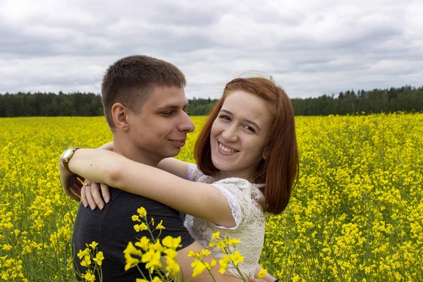 Schönes Paar in einem gelben Rapsfeld — Stockfoto