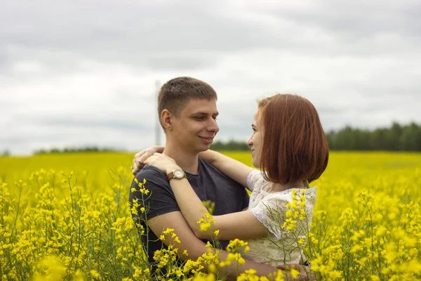 Belo casal em um campo de colza amarelo — Fotografia de Stock