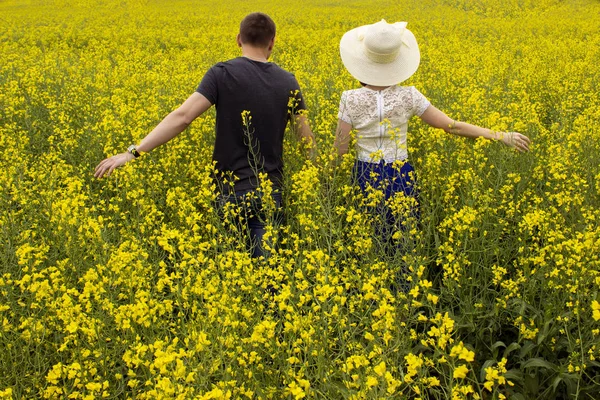 Sarı bir kolza alanında güzel çift — Stok fotoğraf