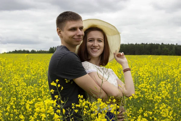 Schönes Paar in einem gelben Rapsfeld — Stockfoto