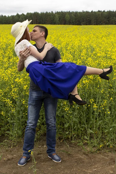 Belo casal beijos em um campo de colza amarelo — Fotografia de Stock