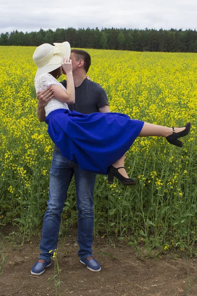 Belo casal beijos em um campo de colza amarelo — Fotografia de Stock