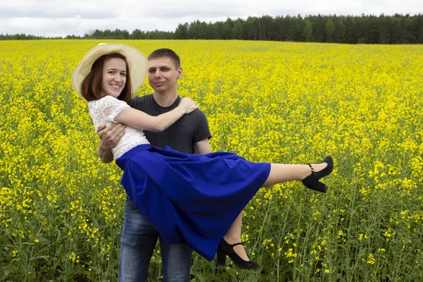 Schönes Paar in einem gelben Rapsfeld — Stockfoto