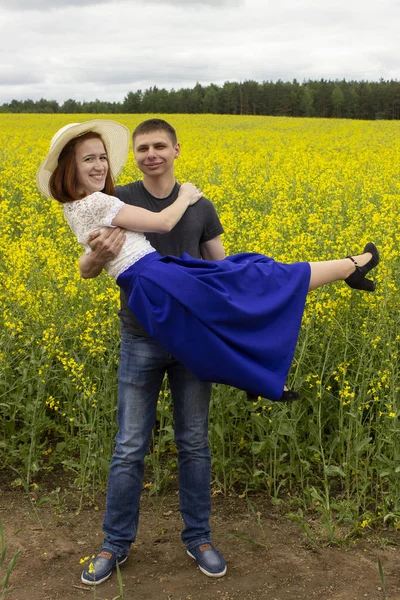 Belo casal em um campo de colza amarelo — Fotografia de Stock