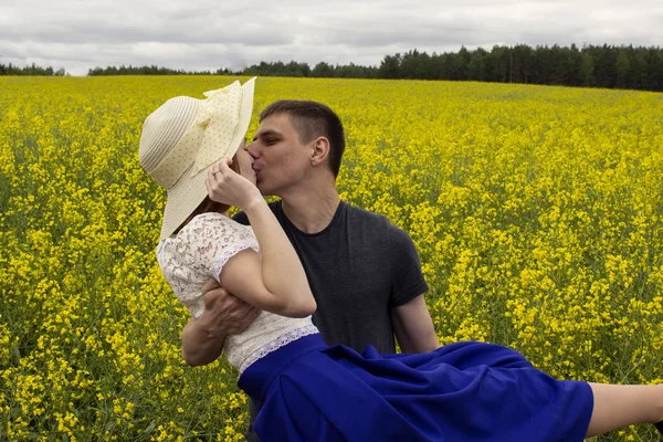 Belo casal beijos em um campo de colza amarelo — Fotografia de Stock