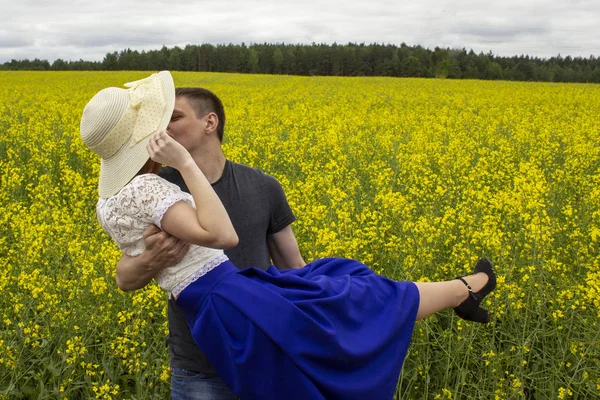 Belo casal beijos em um campo de colza amarelo — Fotografia de Stock