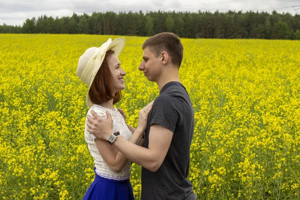 Belo casal em um campo de colza amarelo — Fotografia de Stock