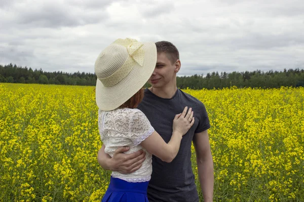 Belo casal beijos em um campo de colza amarelo — Fotografia de Stock