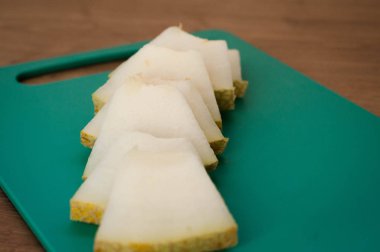 Tahta masa üzerinde kesme tahtası üzerinde dilimlenmiş taze kavun