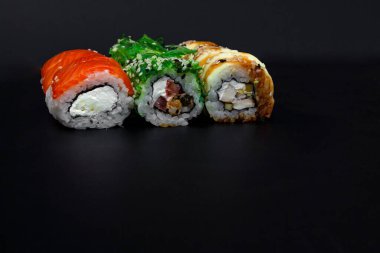 Fotokopi alanı olan büyük bir lezzetli suşi seti. Geleneksel restoranda bir tabakta Japon çiğ balığından bir sürü Philadelphia dürümü var. Japon yemek menüsü servisi