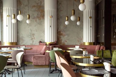 Modern tarzda, dokulu duvarları ve parketi olan bir restoran. Masalı yeşil ve pembe kanepeler var. Tavanda ışıklar var. Minsk, Belarus - 20 Juny 2020