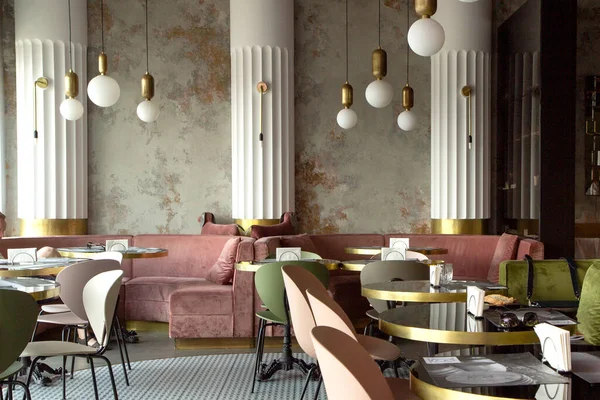 Restaurant dans un style moderne avec murs texturés et parquet. Il y a des canapés verts et roses avec des tables. Au plafond il y a des lumières. Minsk, Bélarus - 20 juny 2020 — Photo